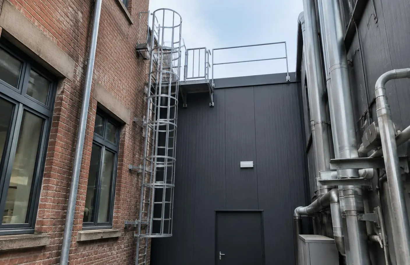 Accès vertical dans une cour étroite entre deux bâtiments existants