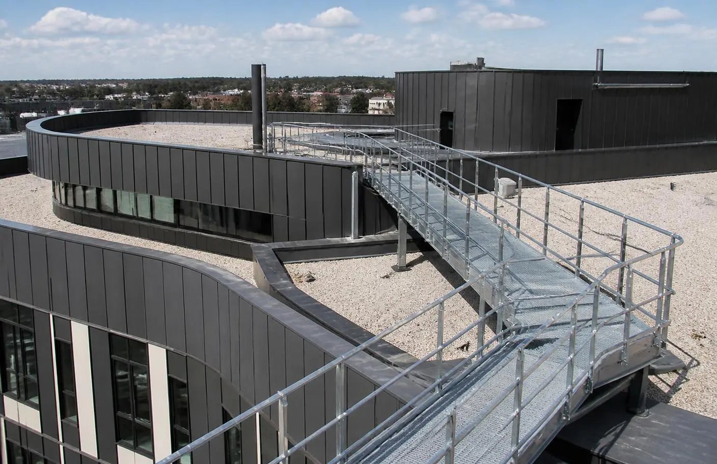 Cheminement métallique adapté aux courbes et aux niveaux d'un bâtiment contemporain