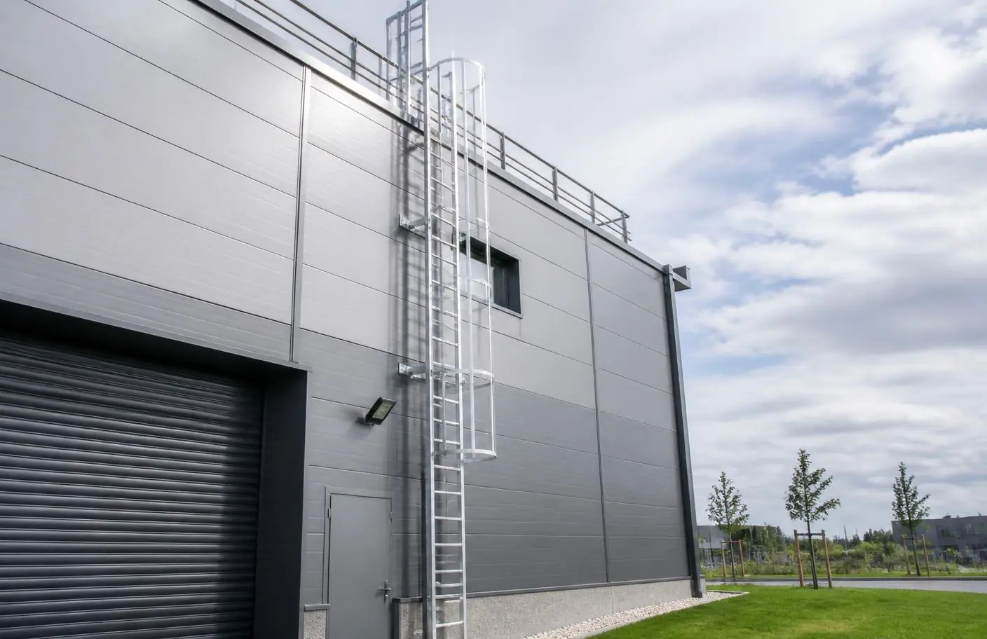 Échelle fixe à crinoline en aluminium sur un bâtiment industriel
